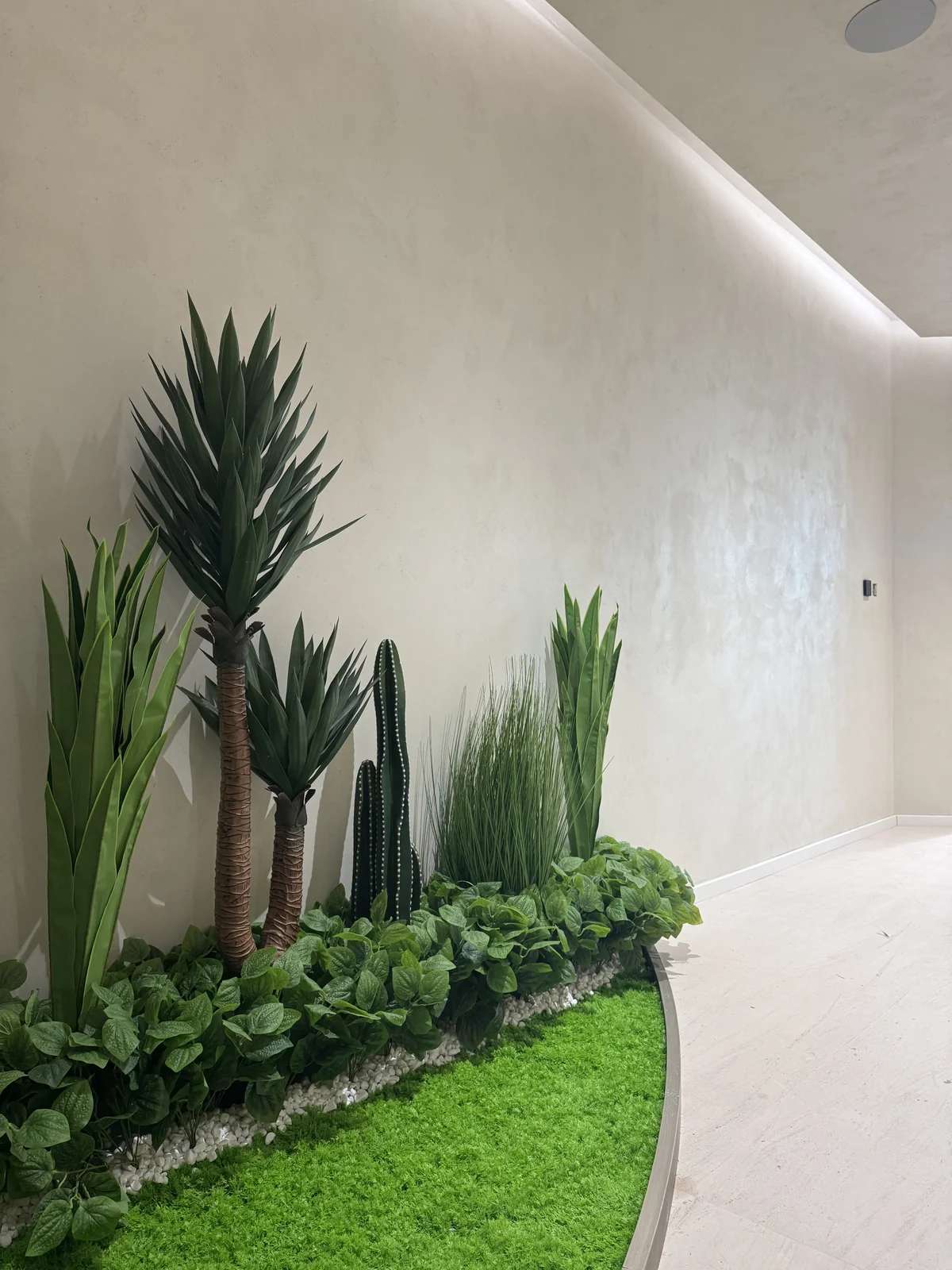 Softly varied wall finish beside an indoor planting feature