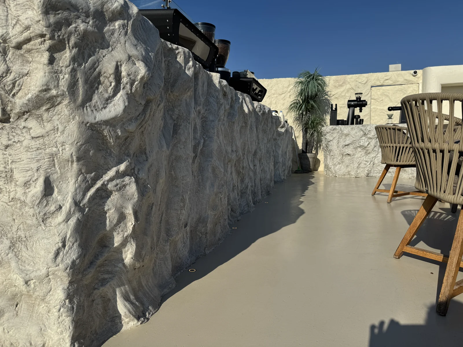 Rough rock-textured café counter with sculpted relief