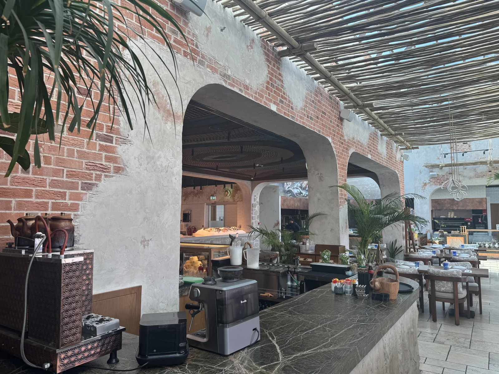 Rustic plaster and brick detailing around restaurant arches