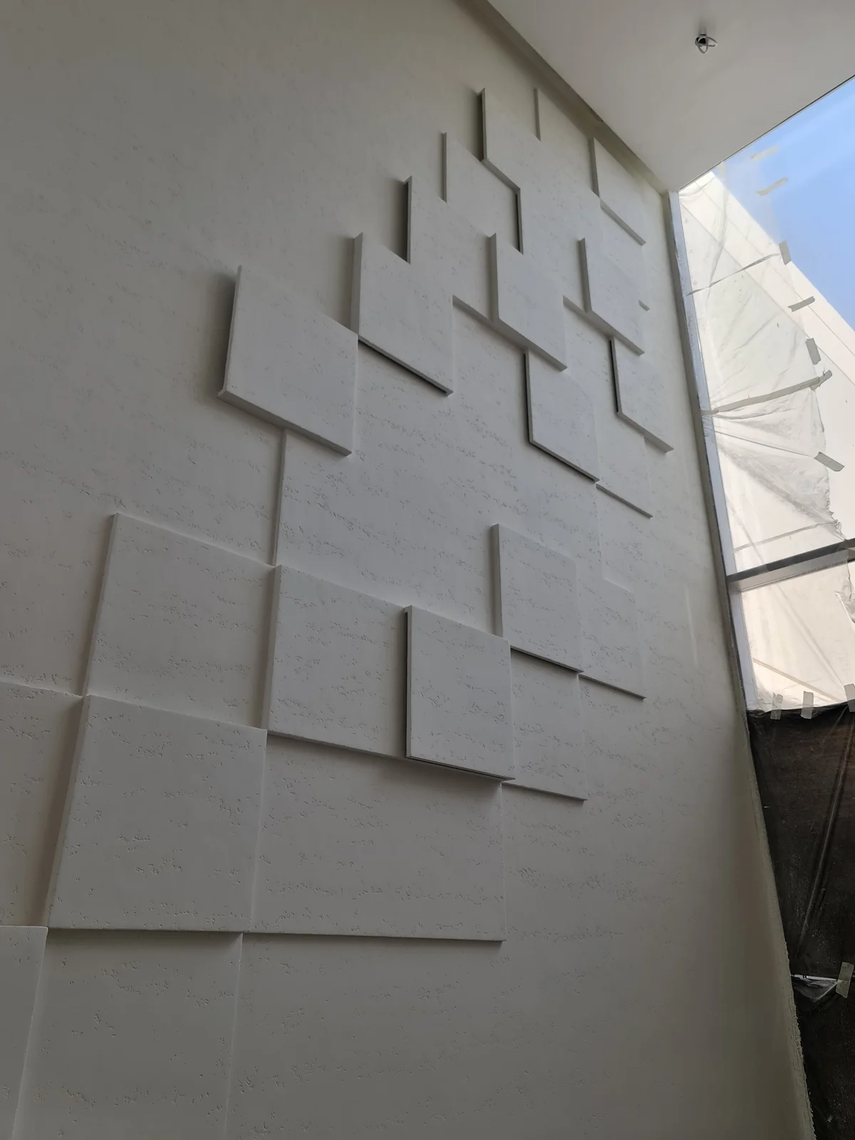 Travertine-effect wall with geometric relief detailing