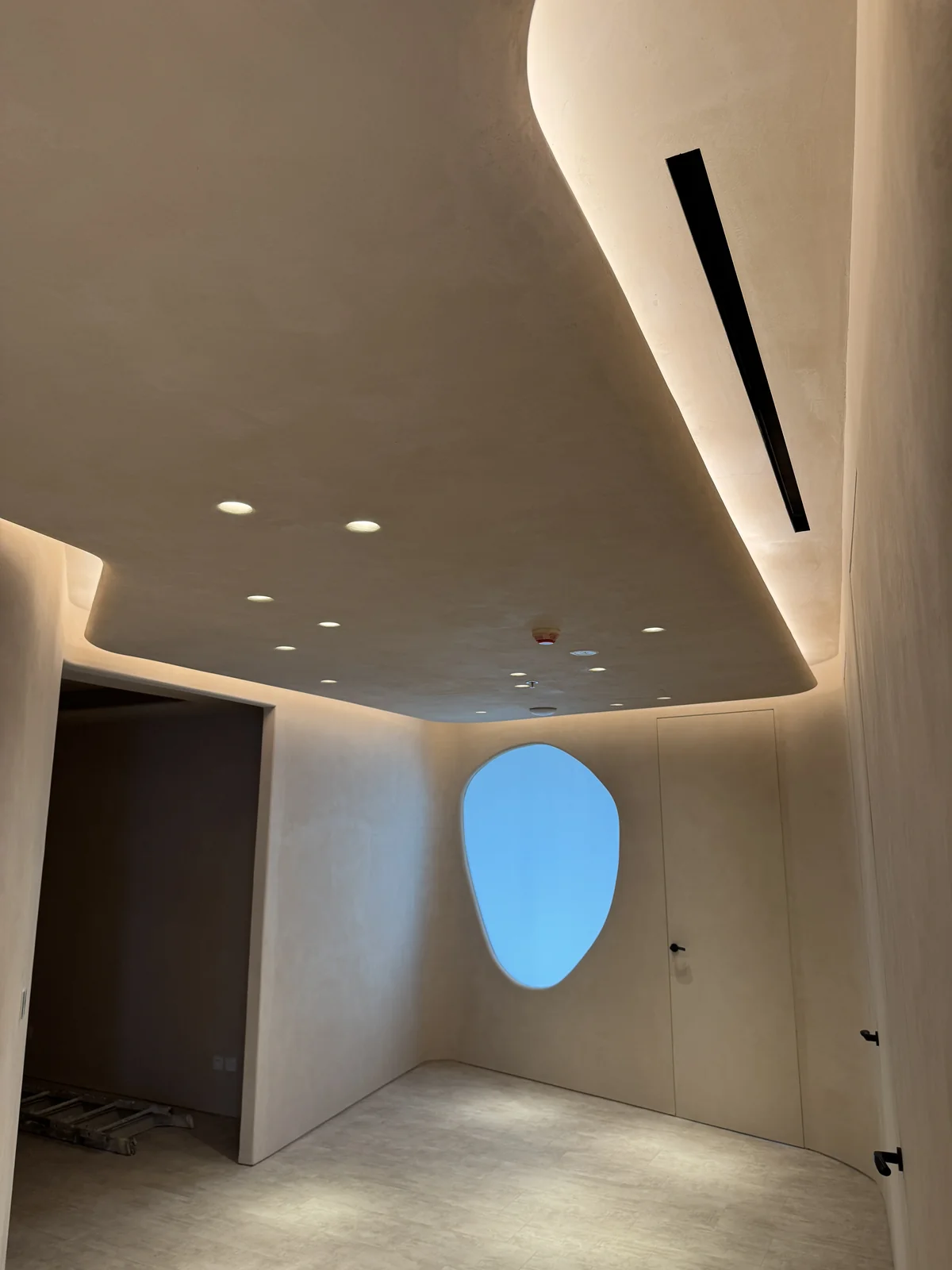 Plaster ceiling and curved lighting details in an office interior