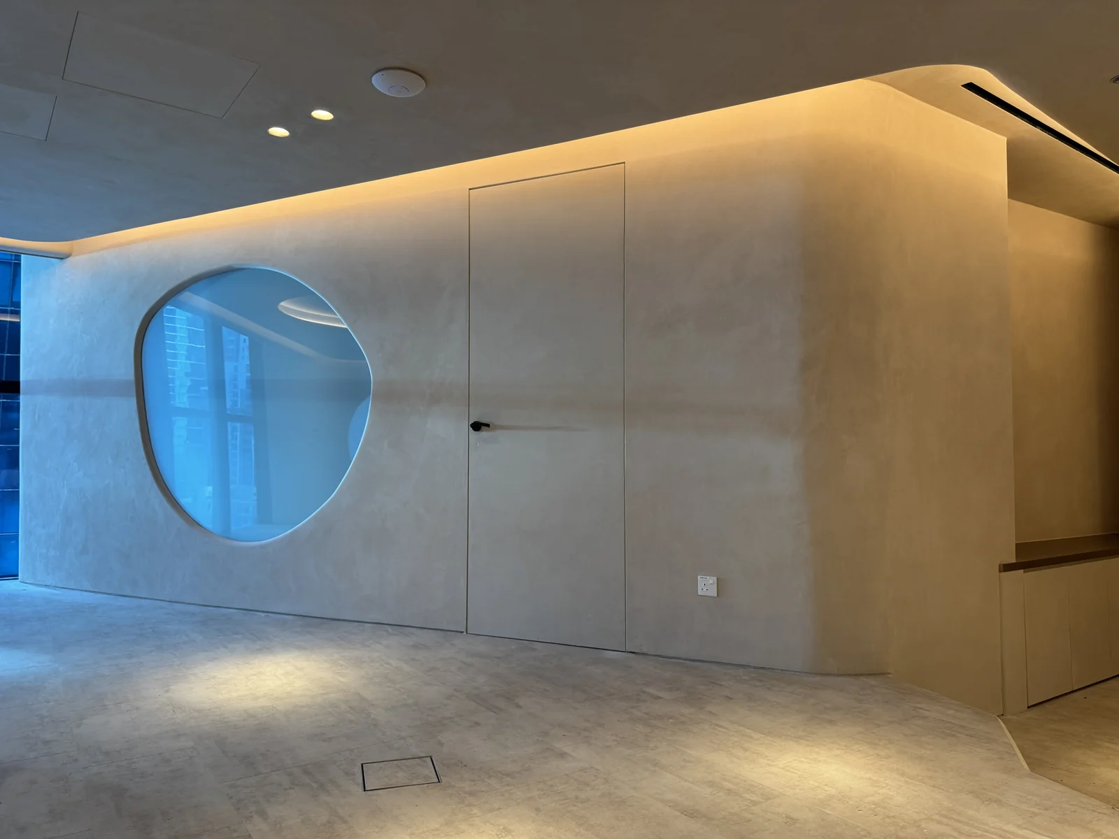 Venetian plaster wall with a curved corner and concealed door