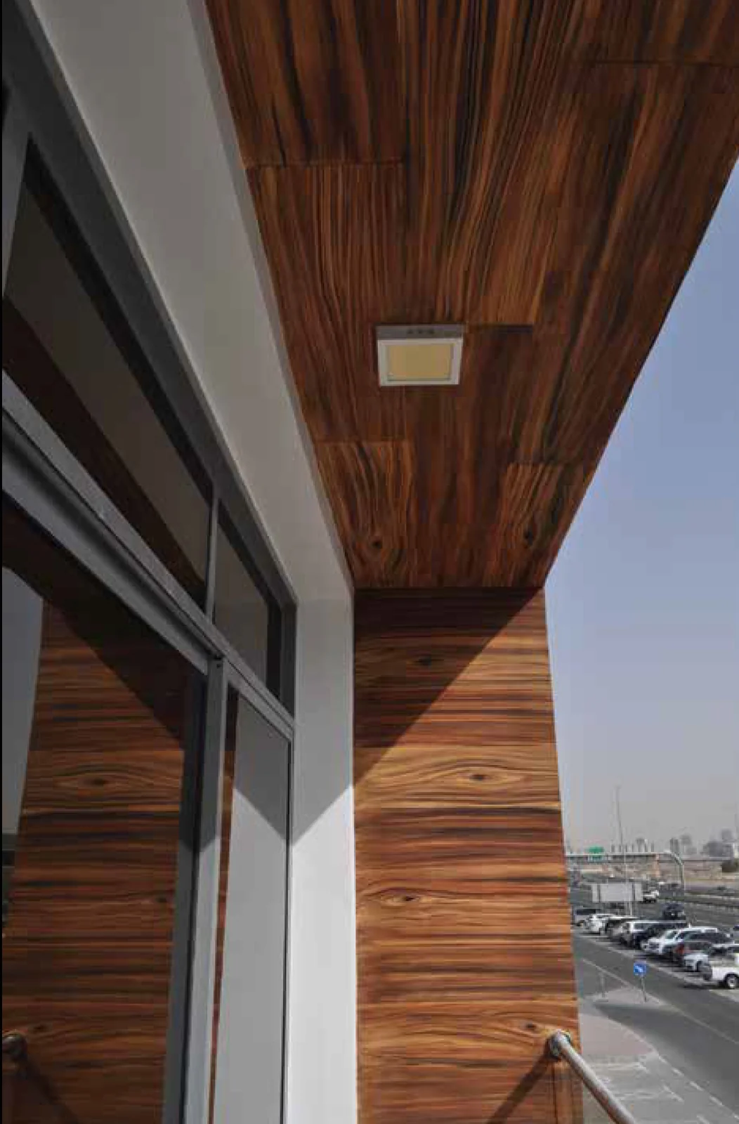 Timber-inspired grain continuing across a soffit and return